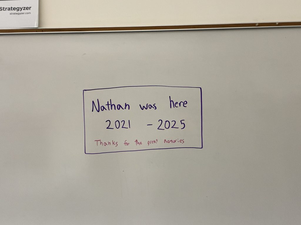 A handwritten message on a whiteboard reads, "Nathan was here 2021 - 2025. Thanks for the great memories," enclosed in a purple rectangular border.
